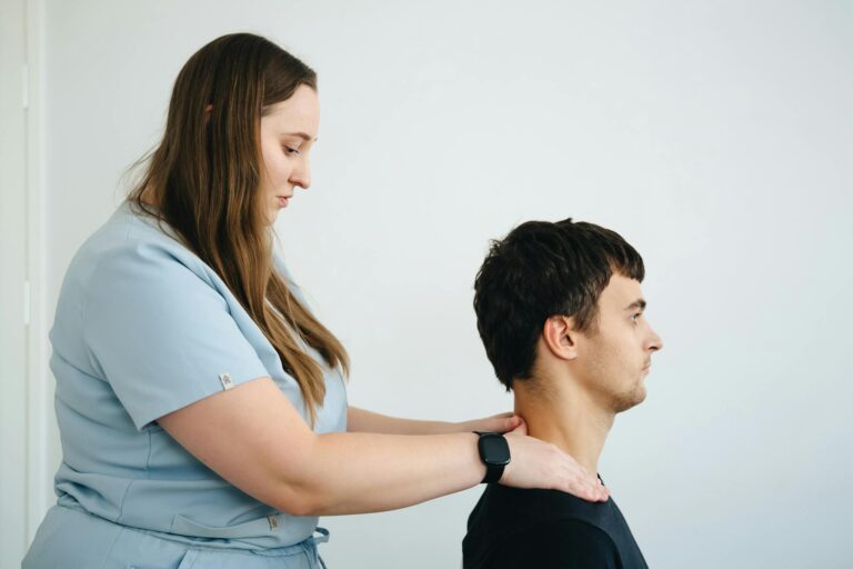 A physiotherapist treating neck pain on a patient in a clinic setting with a focus on healthcare.
